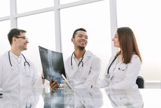 medical colleagues discuss x-ray, sitting at the office table