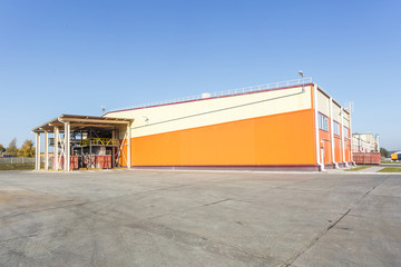 Obraz premium manufacture building of modern waste recycling processing plant in orange style. Separate garbage collection. Recycling and storage of waste for further disposal.