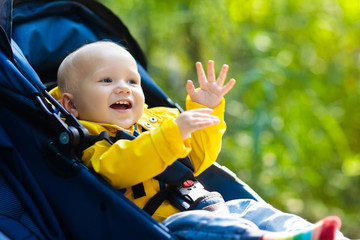 Baby boy in stroller in autumn park