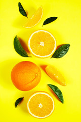 Close up image of juicy organic whole and halved oranges with green leaves & visible core texture,...