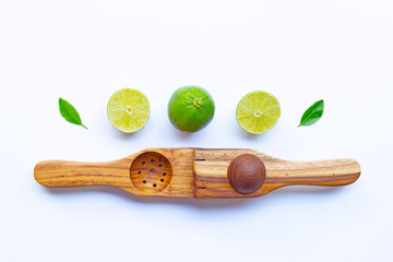 Limes with wooden lime Squeezer on white