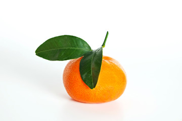 Close up image of one juicy organic whole tangerine with green leaves & visible zest texture,...