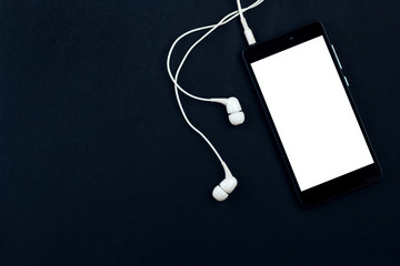 Smartphone and headphones on a black background.  Top view, space for text