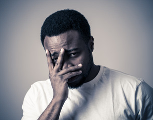 Close up portrait of Unhappy sad young man face suffering from depression and stress