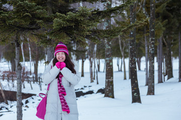 Fototapeta na wymiar Beautiful and happy young Asia Chinese girl in winter snowy day outdoors - Winter Holiday Concept