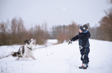 Little boy and his dog in the nature a winters day