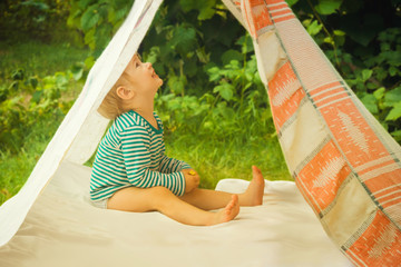 Smeared children play in nature in an improvised house. Homemade tent, hut, for fun girls and boys. Camping © SVIATLANA