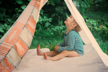 Smeared children play in nature in an improvised house. Homemade tent, hut, for fun girls and boys....