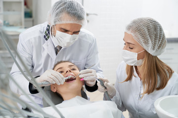 Dentists using restoration instruments for patient.