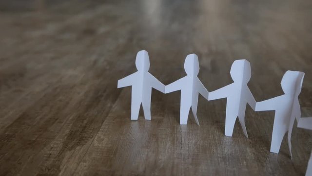 Team of paper doll people standing on the floor