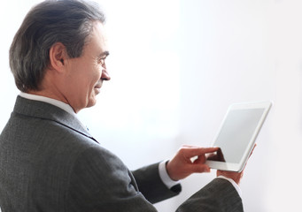 close up. smiling businessman tapping the screen of digital tablet.photo with copy space