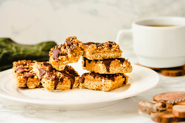 Raw Paleo energy bars made with healthy nuts and dried fruits. Homemade Snack on a white marble table. Diet detox food concept. Sugar free.