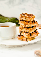 Granola Bars with a cup of coffee, Healthy Homemade Snack, Superfood Bars with Cranberry, Pumpkin Seeds, Oats, Chia and Flax Seed on bright background, Vegan Meal. Selective focus