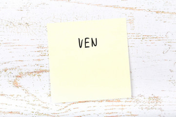 Yellow sticky note with handwritten text ven