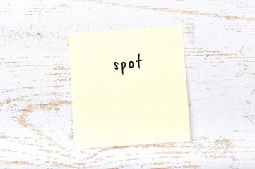 Yellow sticky note with handwritten text spot