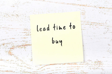 Yellow sticky note with handwritten text lead time to buy
