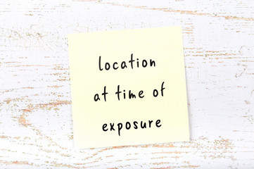 Yellow sticky note with handwritten text location at time of exposure
