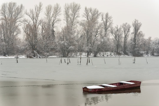 Beautiful frozen river. A boats covered with snow.