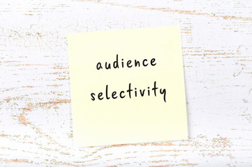 Yellow sticky note with handwritten text audience selectivity