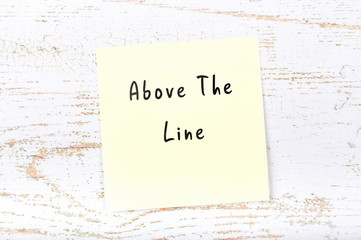 Yellow sticky note with handwritten text above the line
