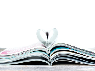 Fototapeta premium Heart shape on stack magazines with white background.