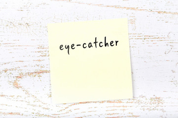 Yellow sticky note with handwritten text eyecatcher