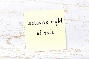 Yellow sticky note with handwritten text exclusive right of sale