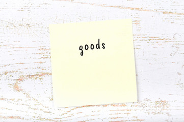 Yellow sticky note with handwritten text goods