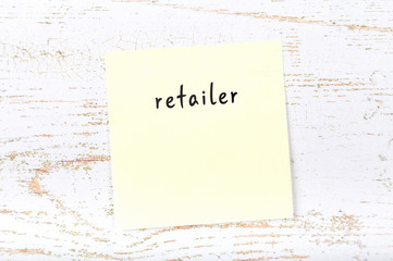 Yellow sticky note with handwritten text retailer
