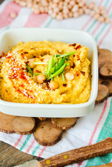 Hummus, chickpea dip, with rosemary, smoked paprika and olive oil on a wooden background. Rustic. Healthy lifestyle and balanced food concept.Close-up.