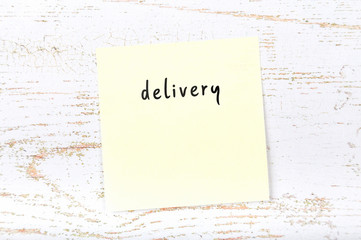 Yellow sticky note with handwritten text delivery