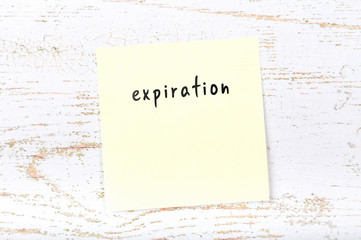 Yellow sticky note with handwritten text expiration