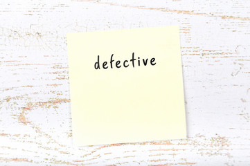 Yellow sticky note with handwritten text defective