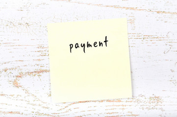 Yellow sticky note with handwritten text payment