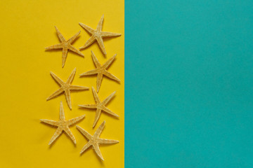 Summer background of yellow and blue paper with starfish, symbol