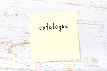 Yellow sticky note with handwritten text catalogue