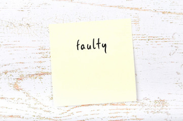 Yellow sticky note with handwritten text faulty