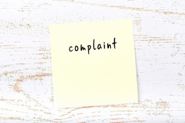 Yellow sticky note with handwritten text complaint