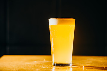 Glass of light and dark beer in a pub. Dark background.