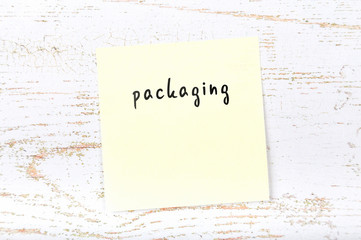 Yellow sticky note with handwritten text packaging
