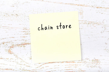 Yellow sticky note with handwritten text chain store