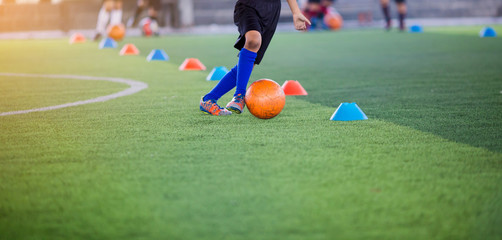 boy soccer player trap and control football between cone makers