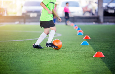boy soccer player trap and control football between cone makers
