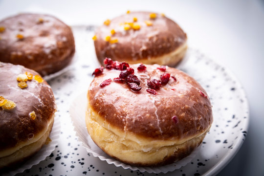 Cukiernia, tradycyjne pączki z lukrem. Apetyczne słodkie ciastka na kuchennym stole.