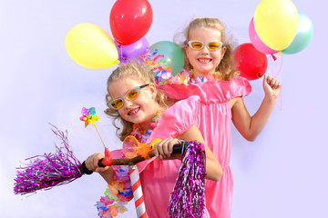 Twin sisters play together riding an imaginative bicycle. They use a rusty handlebar they found in the garage. They fit it with fringes, a windmill and an orange plastic horn.