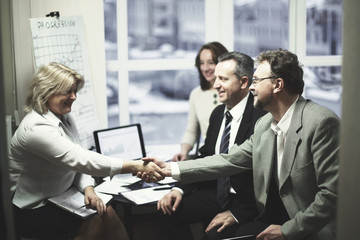business handshake women with a partner over a Desk