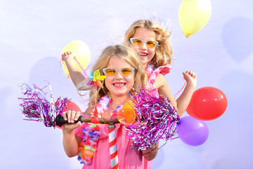 Twin sisters play together riding an imaginative bicycle. They use a rusty handlebar they found in the garage. They fit it with fringes, a windmill and an orange plastic horn.