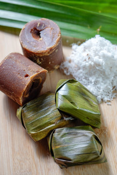 Koci the malay glutinous rice ball served in banana leaf on white plate over wooden table