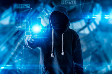 The abstract image of the hacker standing overlay with futuristic hologram and the future cityscape is backdrop. the concept of cyber attack, virus, malware, illegally and cyber security.
