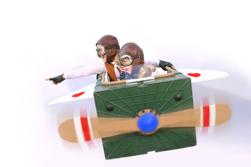 The red heart airways flies through the sky with twin sisters  sitting at the controls. They play happily pilot and co-pilot  with an airplane made from things found in their garden. © Brigitte